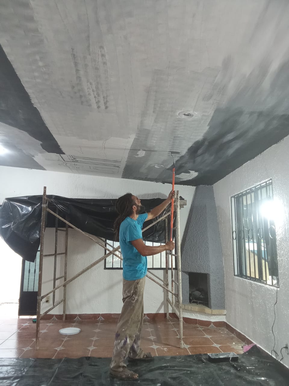 Jorge pintando a mano alzada sobre andamio en altura